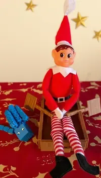 Rampenissen ror i båt med en blå squid svømmende ved siden av.